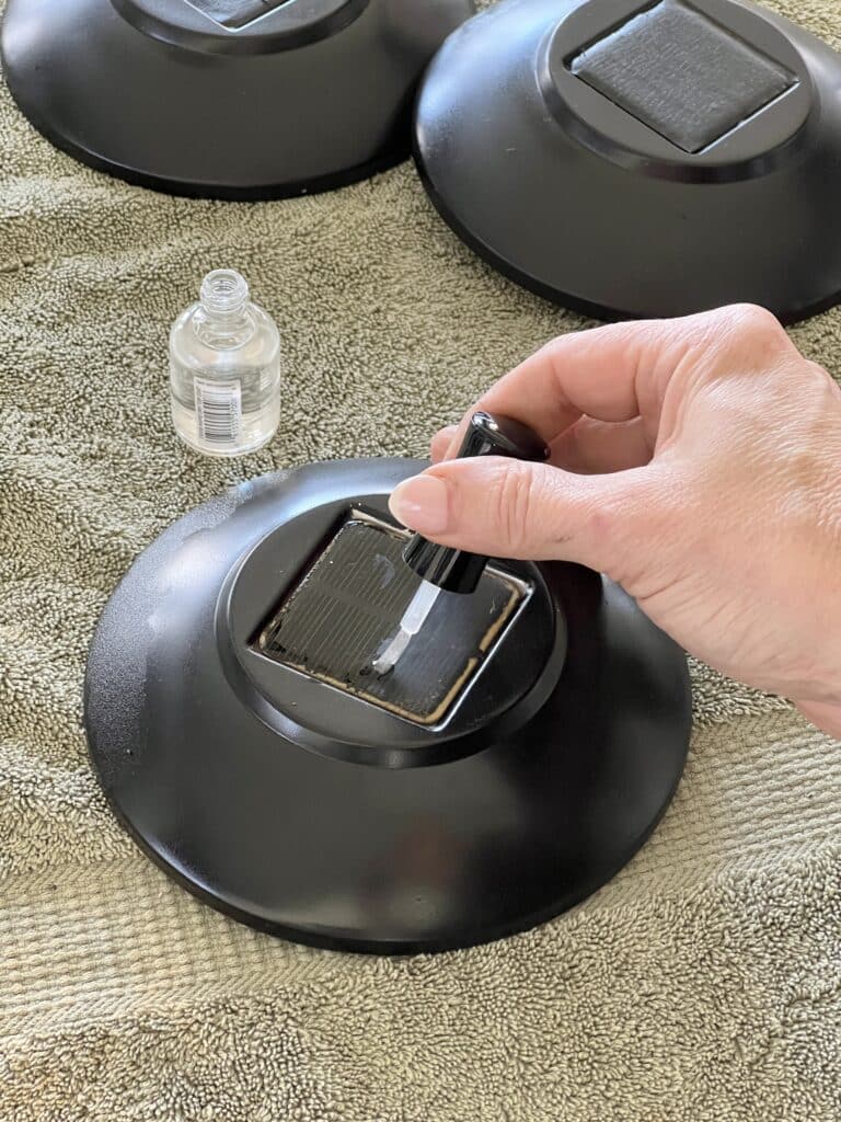 Brushing clear nail polish on to the solar light panel to restore the light's ability to gather and store energy.