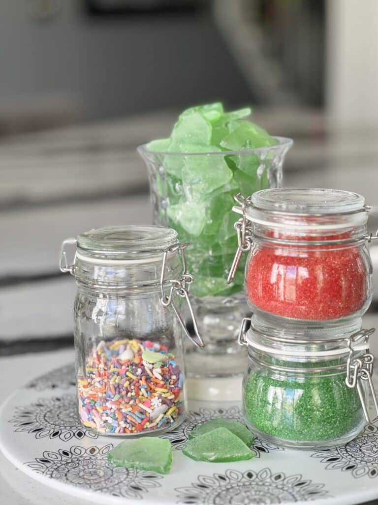 Colored sprinkles are displayed in sealed glass jars.