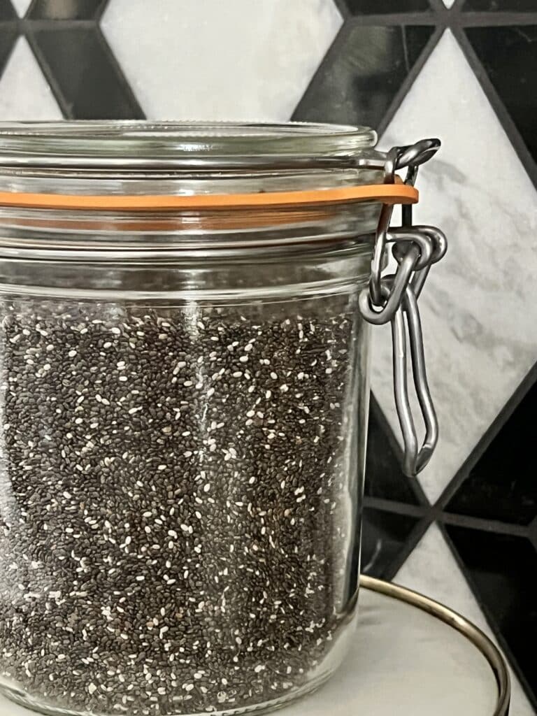 Chia seeds stored in a sealed lidded glass jar in the kitchen.