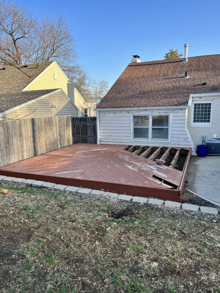 A dilapidated deck that is missing floor boards.