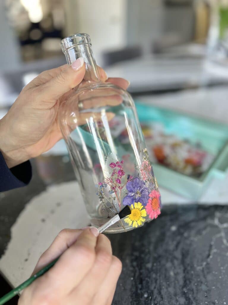 Applying flowers to the vase decor in the kitchen.