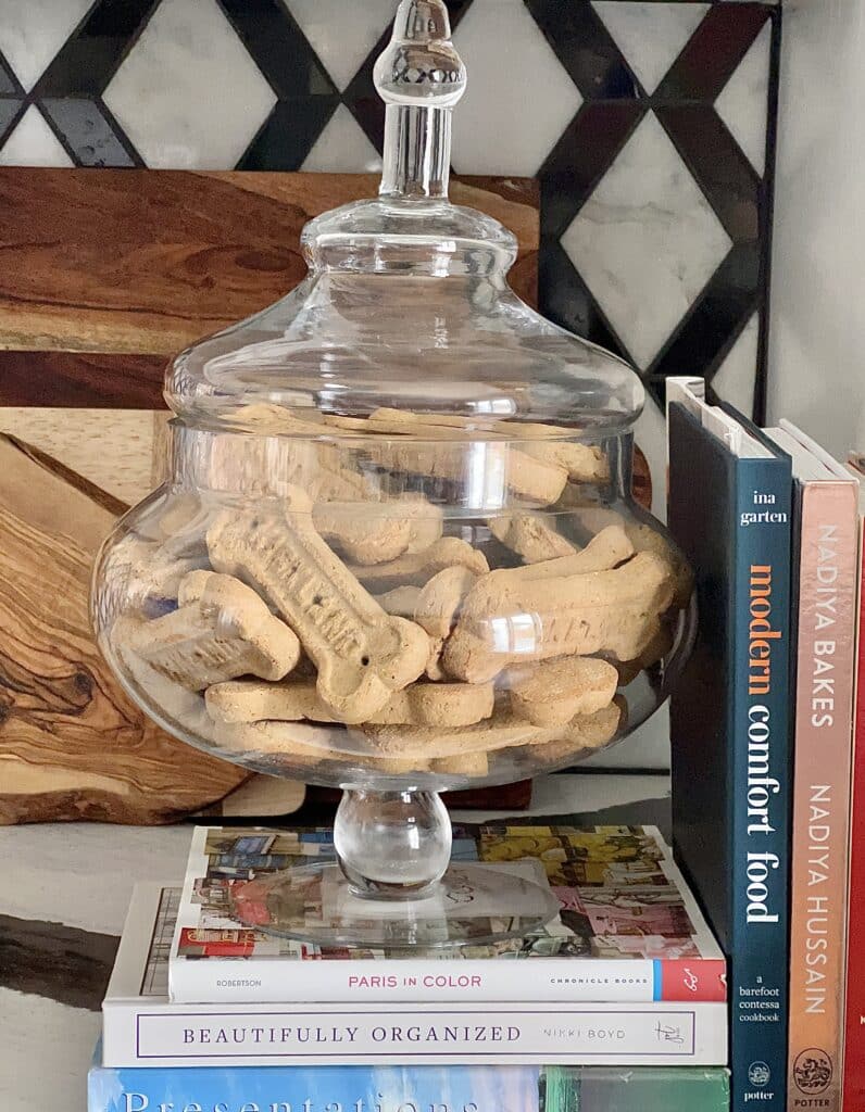 An apothecary jar holding dog treats.