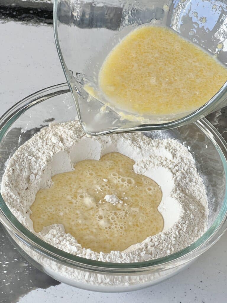 Pouring the wet ingredients of the sausage muffin recipe into the dry ingredients.