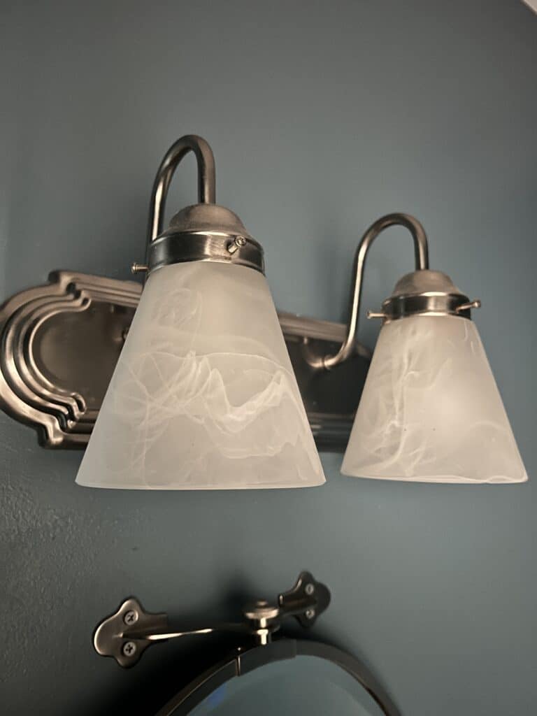 Half bath makeover - overhead light fixture that casts shadows on the face.