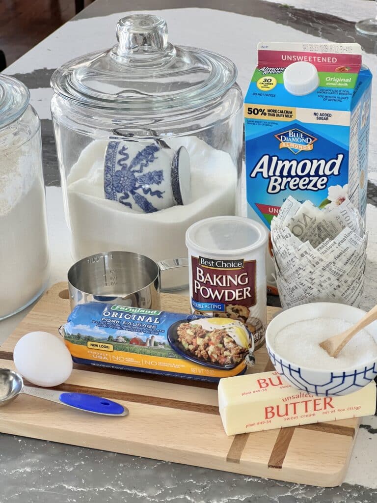 Ingredients for the sausage muffin recipe that includes flour, sugar, egg, salt, butter, milk, pork sausage, and cheddar cheese.