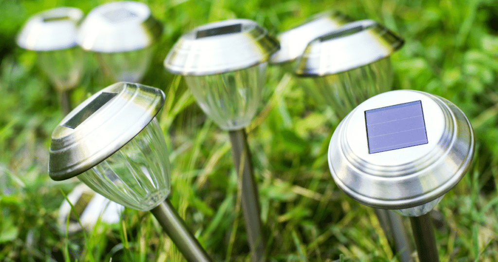 A bundle of silver solar pathway lights in green grass.