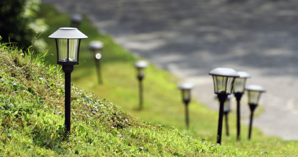 Solar lights that are stuck into the ground on a hill.