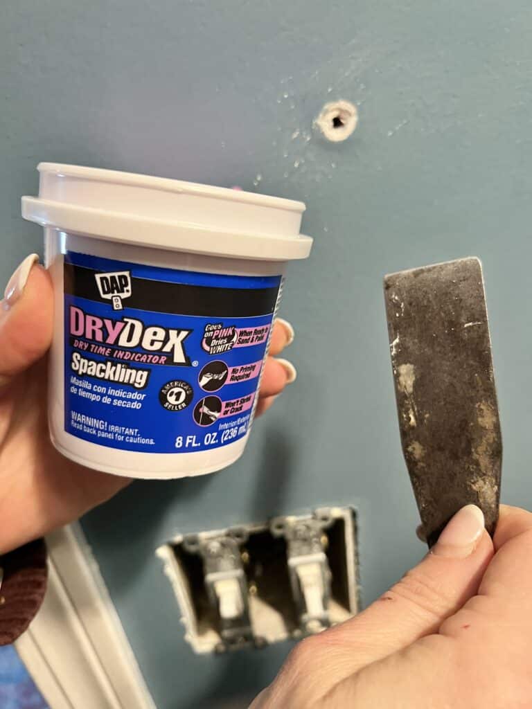 Spackling a wall for the best paint primer for the dark walls.