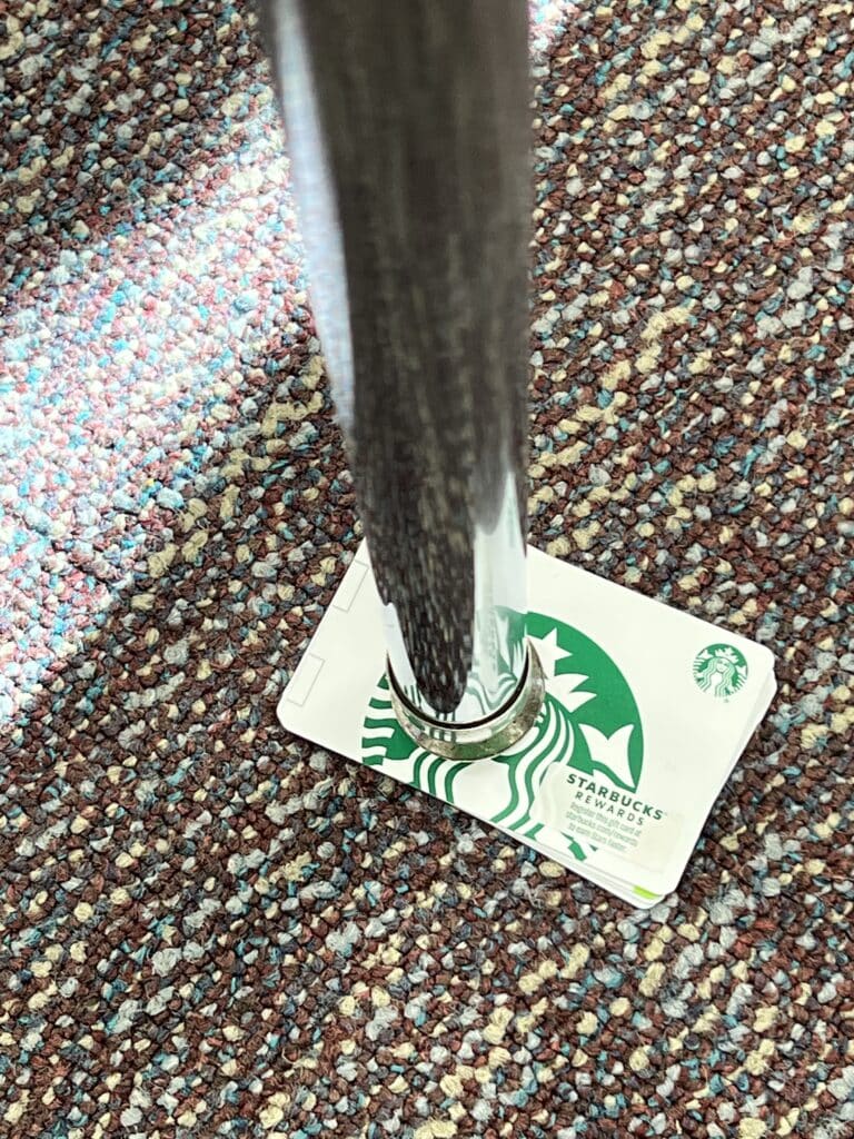 A Starbucks gift card tucked under a table leg to correct a wobbly table.