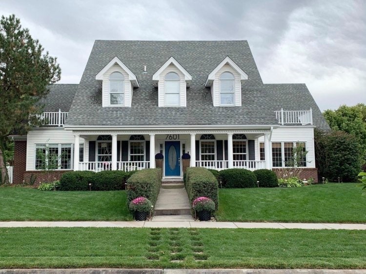 The front exterior of our home with large metal house numbers on the front.