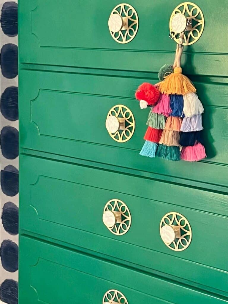 An upcycled dresser that has been painted green and given new gold hardware pulls.