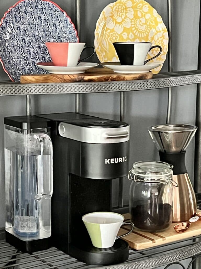 A coffee machine and ground coffee sitting on a wood cutting board.