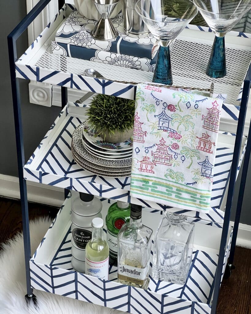 A utility cart from Ikea turned into a bar cart using wallpaper.