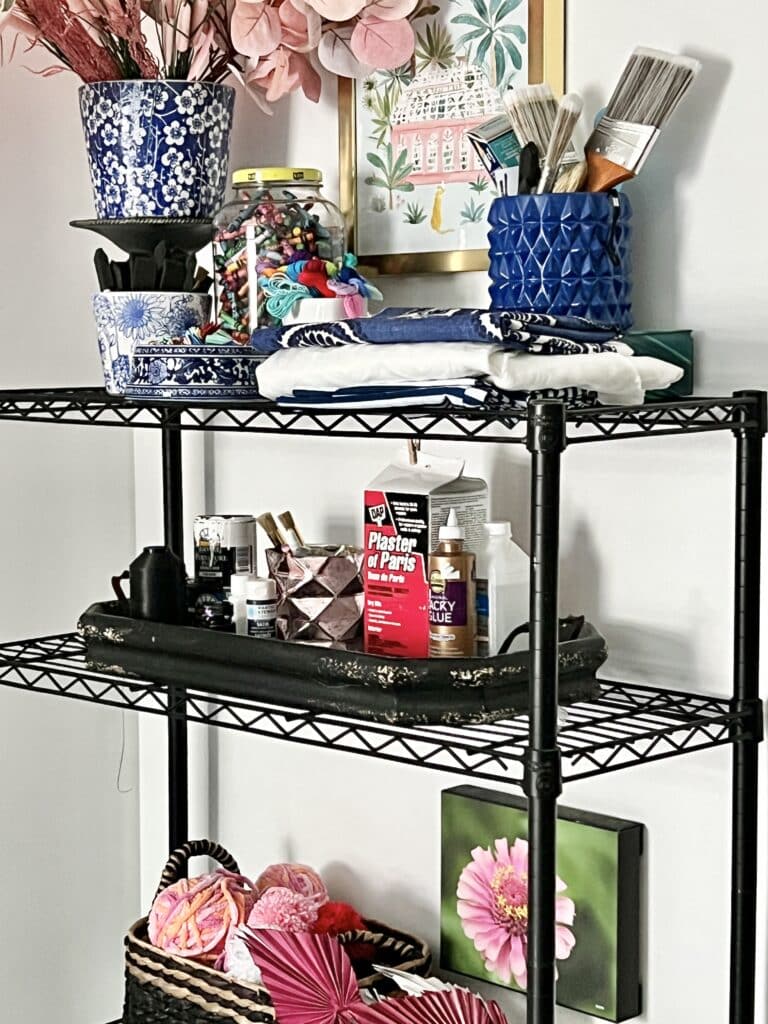 Art and craft supplies sitting on a metal rack.