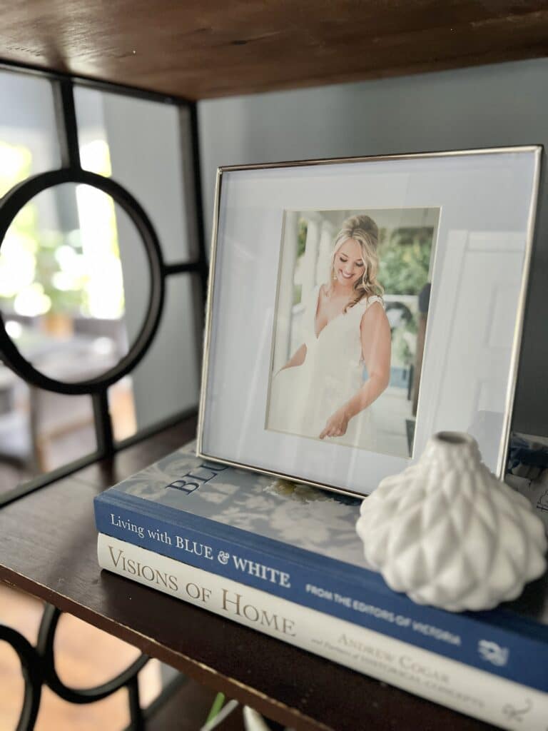 Kitchen Bakers Rack Decorating Ideas - A family photo sitting on top of a stack of home decor books on a baker's rack.