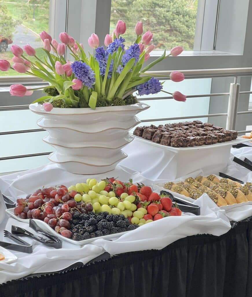 The buffet display at the Friends of Opera event including fresh fruit, brownie bites, and chocolate dipped madelaines.