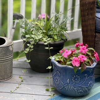 A blue ceramic pot from Saved from Salvage sitting on a patio.