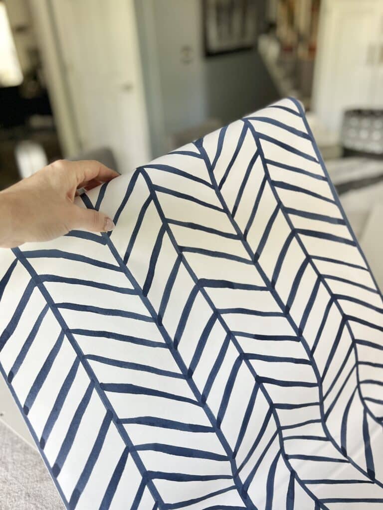 A roll of blue and white wallpaper in an alternating chevron pattern.