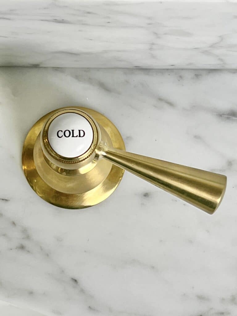 A vanity sink faucet handle marked "cold."
