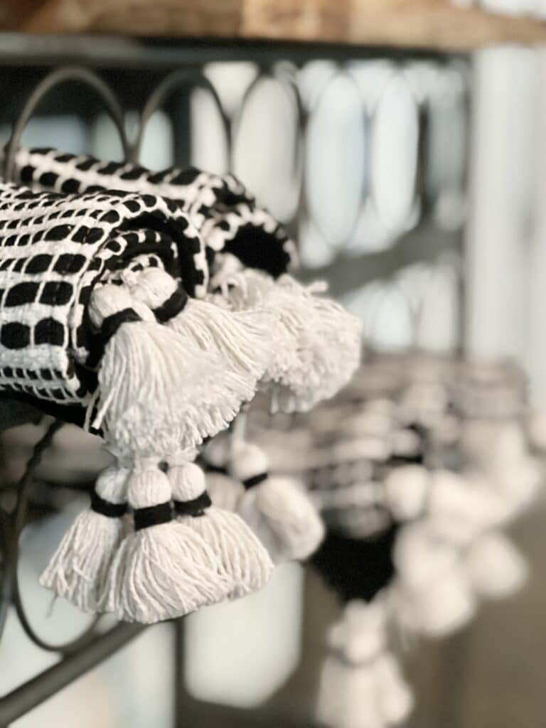 Black and white placemats tucked into the wine cubby holes of a baker's rack.