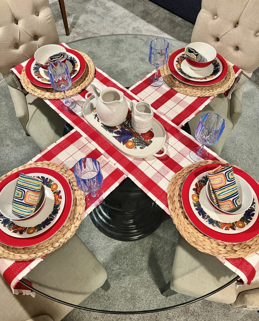 Two table runners that are criss-crossed on a round glass table.