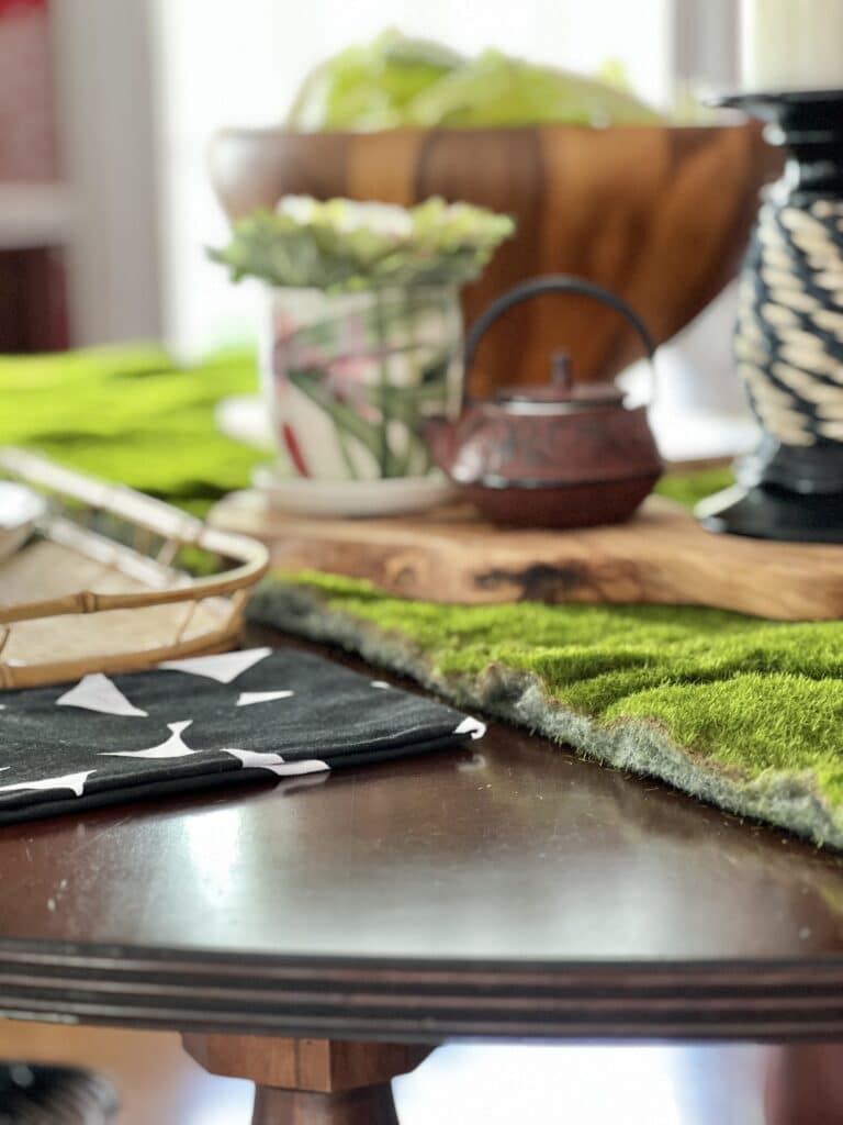 A faux moss table runner on a round dining table.