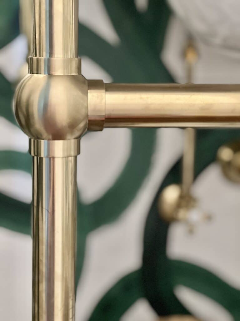 Gold pipes on the sink are a half bath idea to make a small room feel larger through reflection.