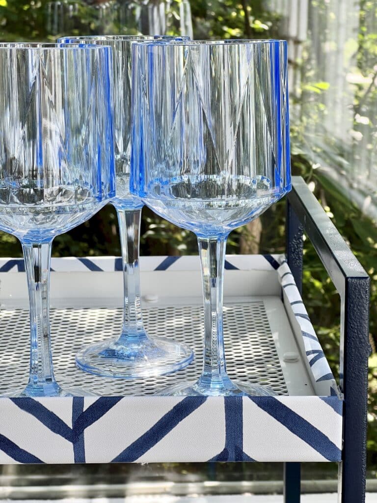 Blue wineglasses sitting atop a DIY Ikea bar cart.