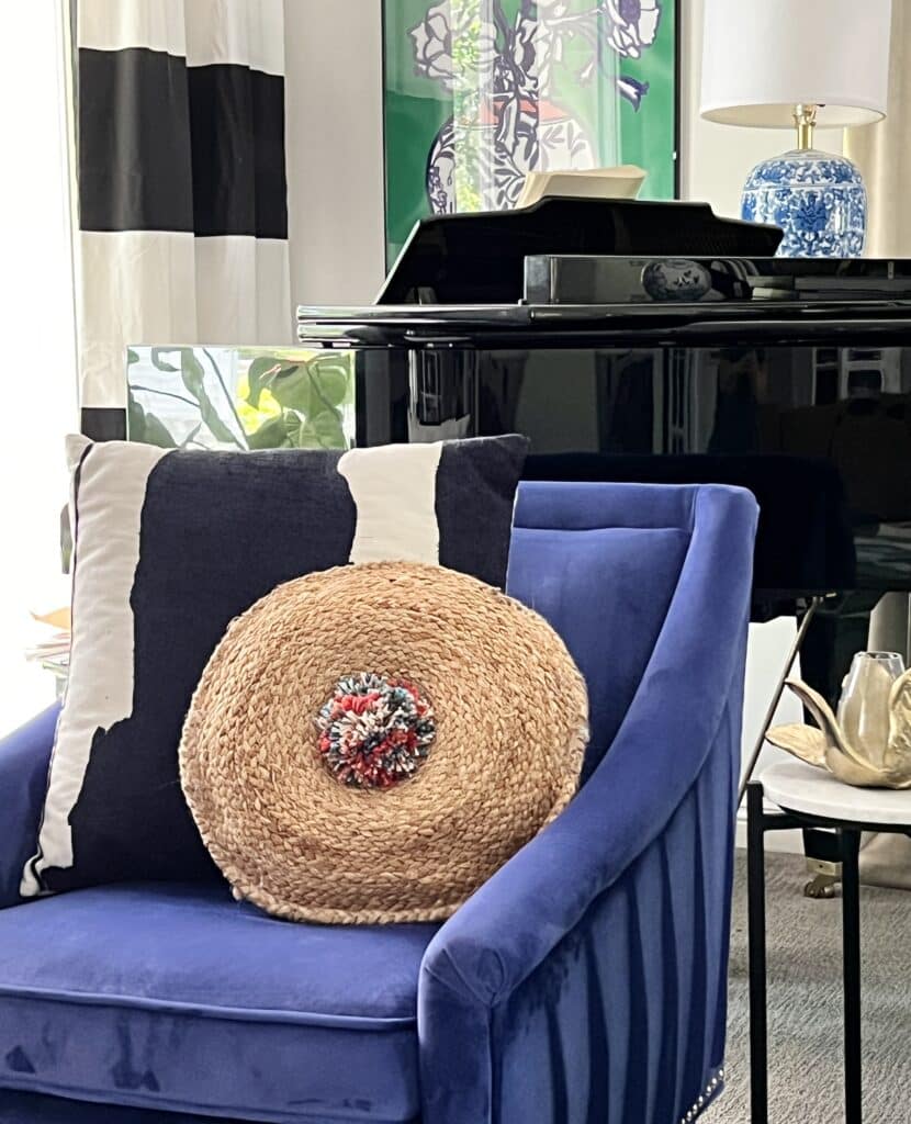 A DIY boho pillow with a pom pom in the middle.