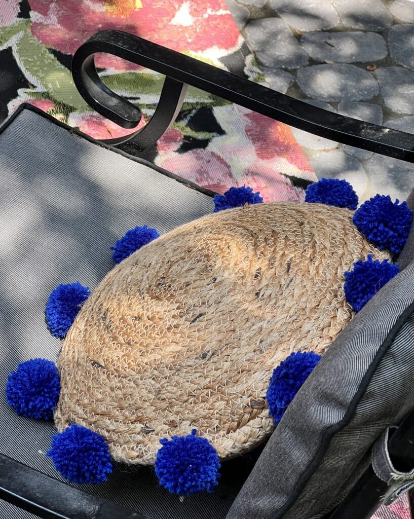 A DIY boho pillow sitting on a patio chair.