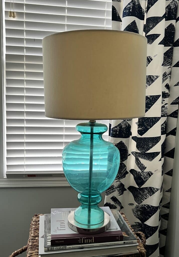 A basic lamp with a blue base and a yellowed shade that is in need of a lamp makeover.
