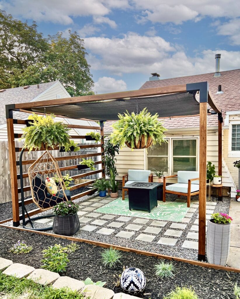 The completed Toja Grid pergola sitting on top of a pea gravel patio.