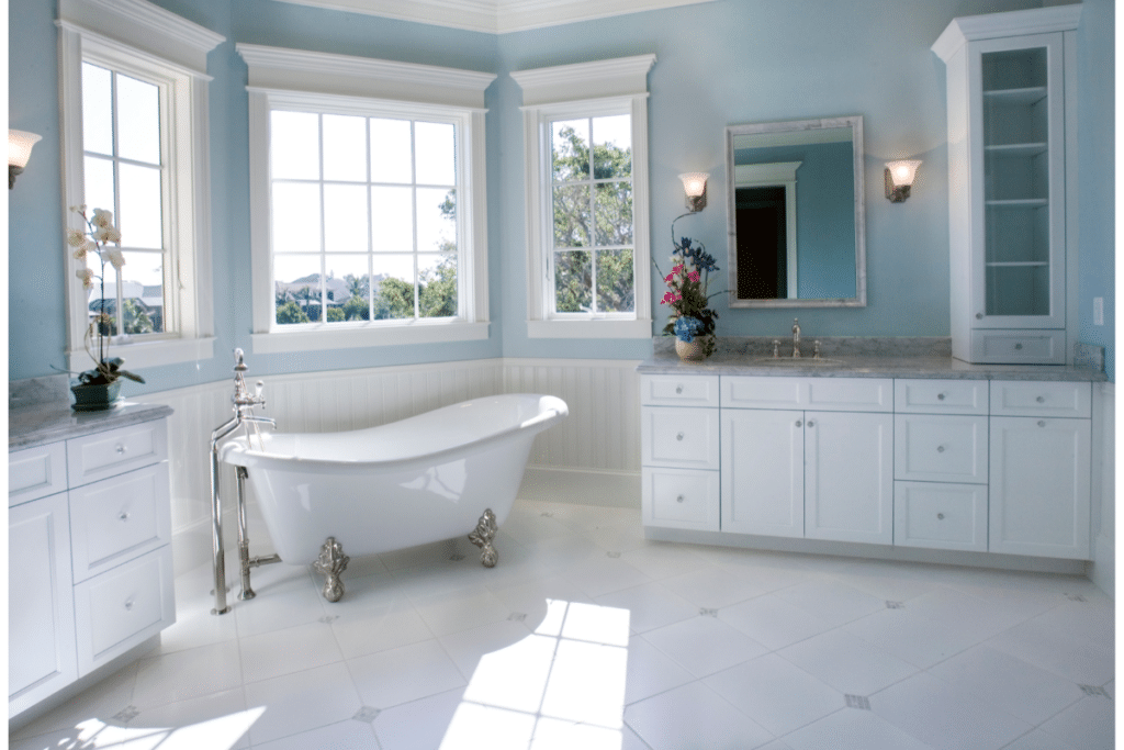 A large bathroom with two wall sconces on either side of the mirror.