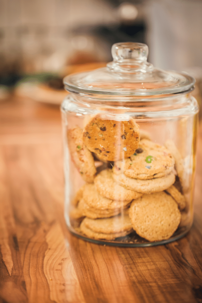 A glass canister full of cookies.