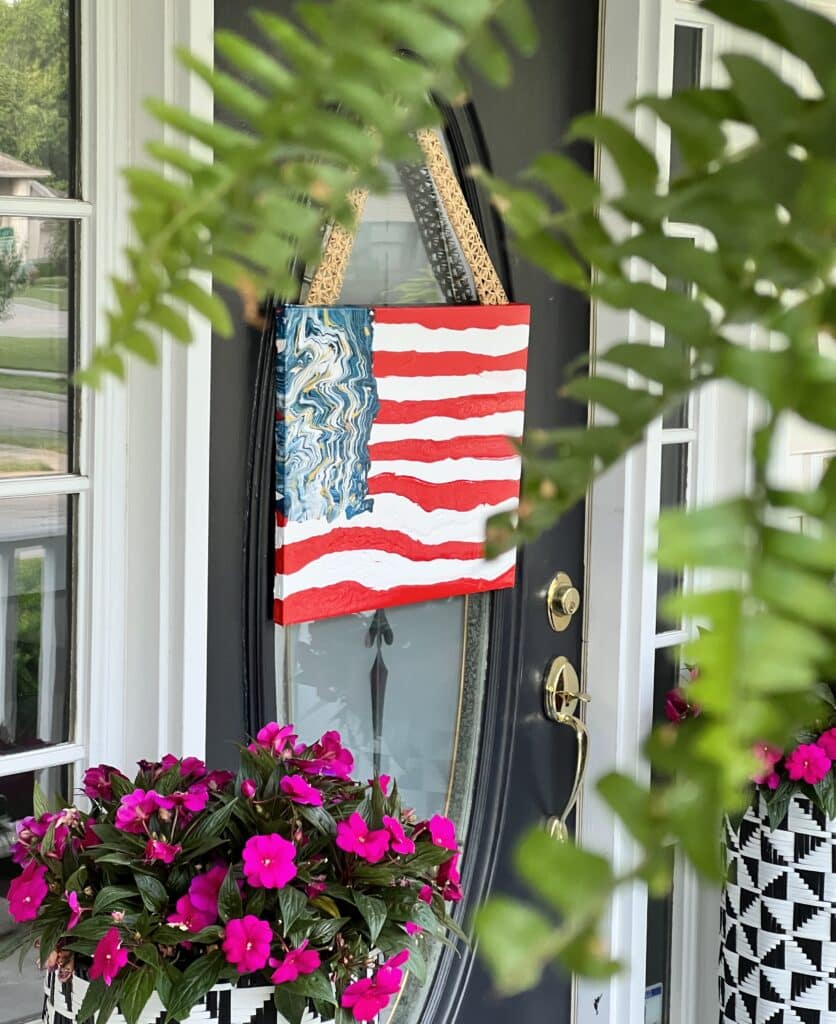 The DIY abstract wall art flag hanging from a rattan ribbon on the front door.