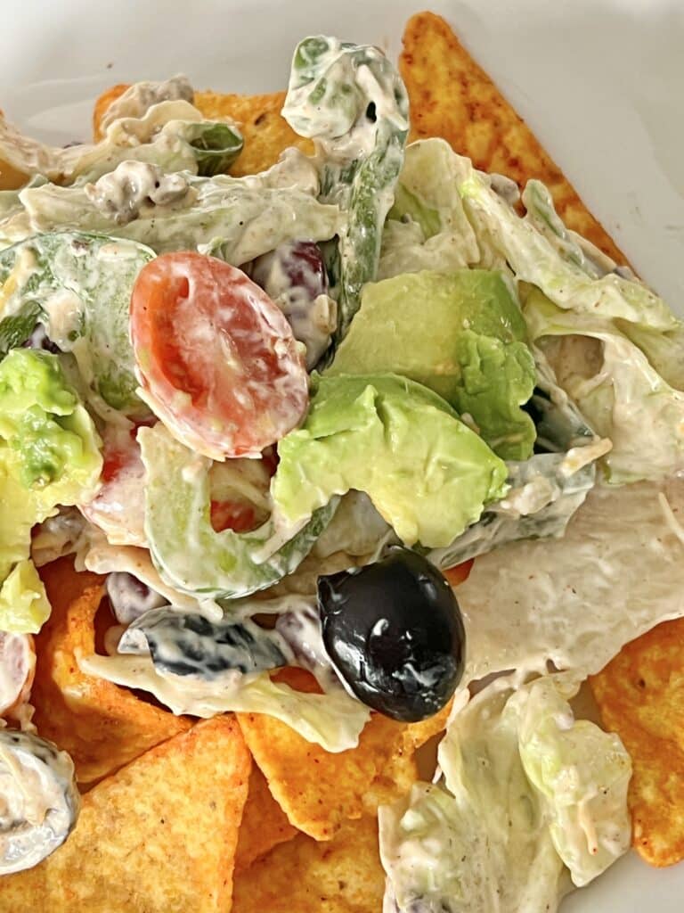 A Mexican tostada salad with tortilla chips and a creamy taco dressing.