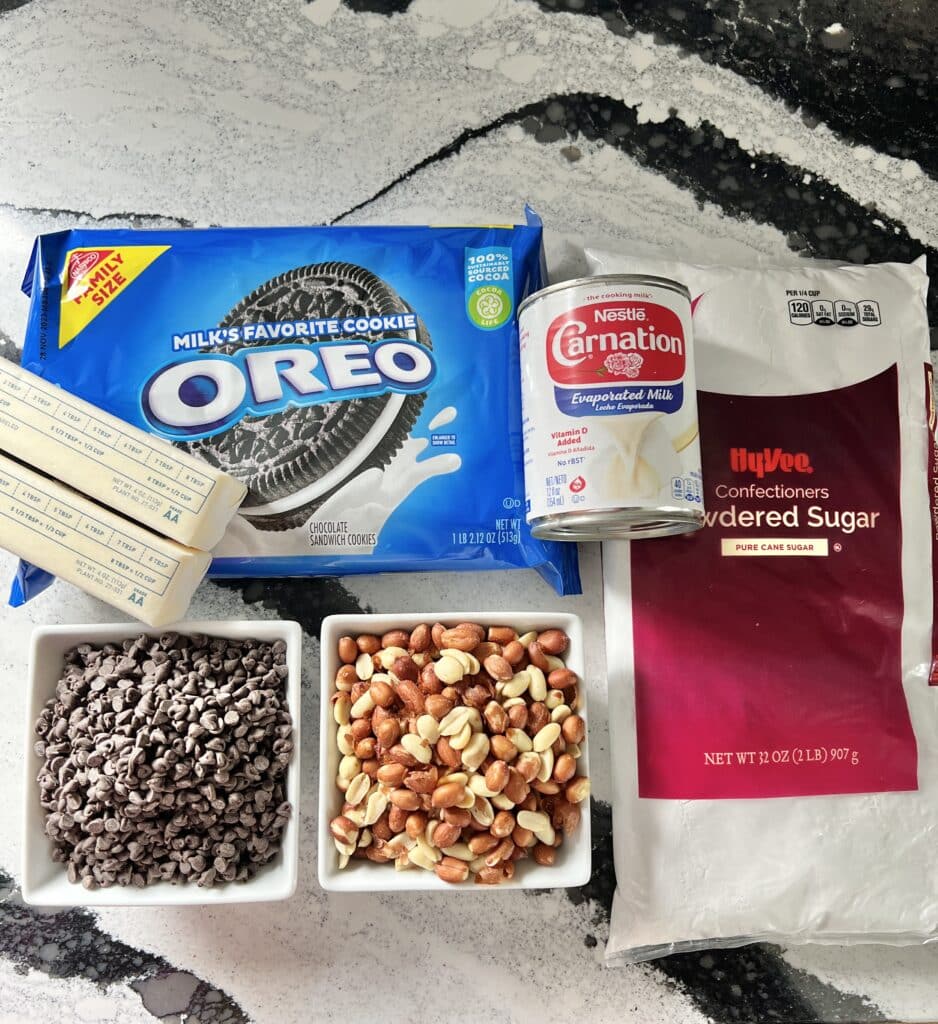 The ingredients for the Buster Bar recipes include Oreo cookies, evaporated milk, powdered sugar, butter, chocolate chips, and Spanish peanuts.