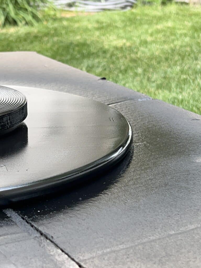 A Lazy Susan that has been spray painted black.