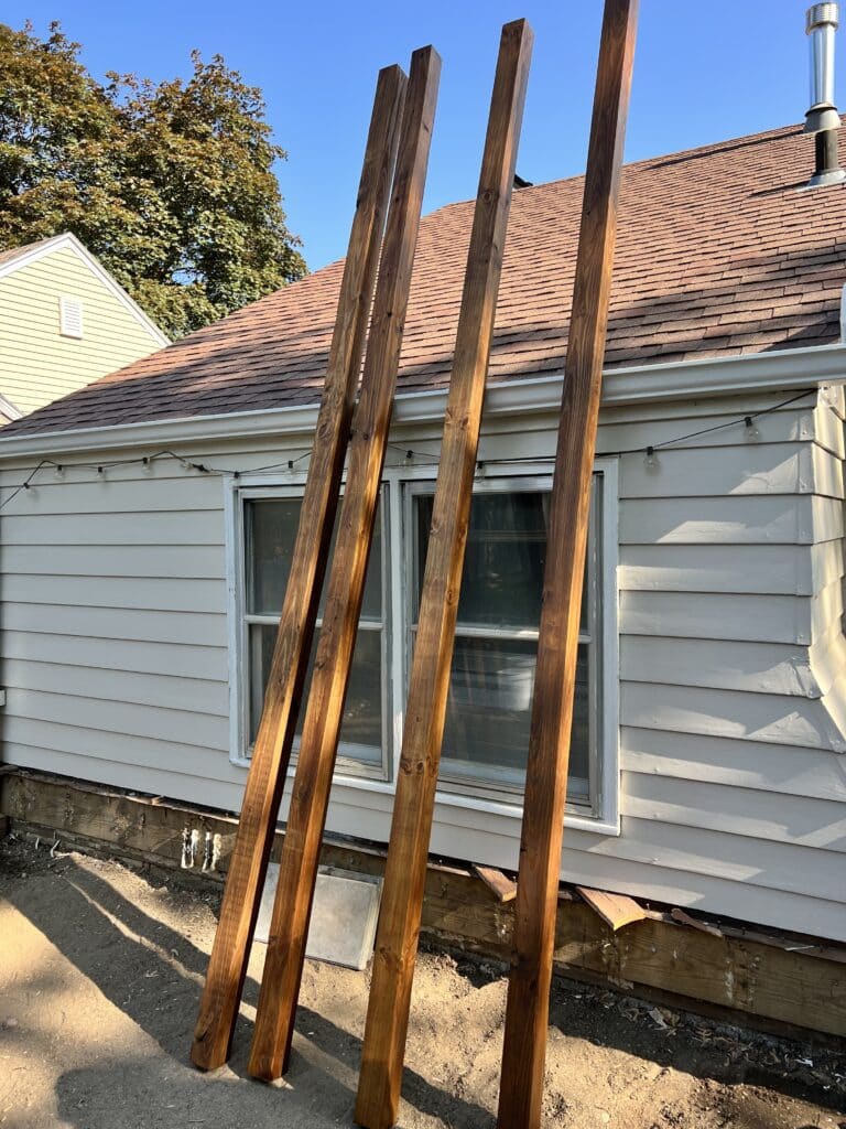 Wood beams that have been stained in preparation for the DIY pergola kit.