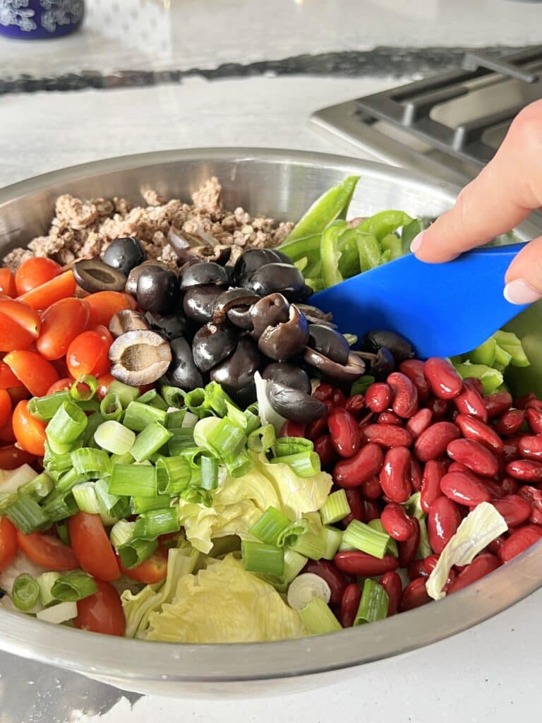 Stirring all of the ingredients together in a large bowl for the Mexican tostada salad.