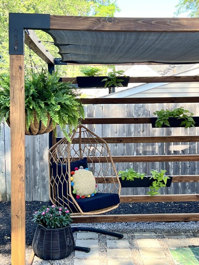 The completed Toja Grid DIY pergola kit that has a wood beam wall.