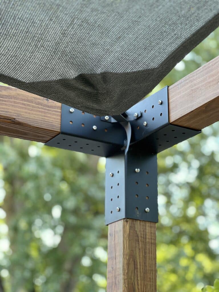 The Toja Grid shade sail is clipped to the corner of the DIY pergola kits hardware.