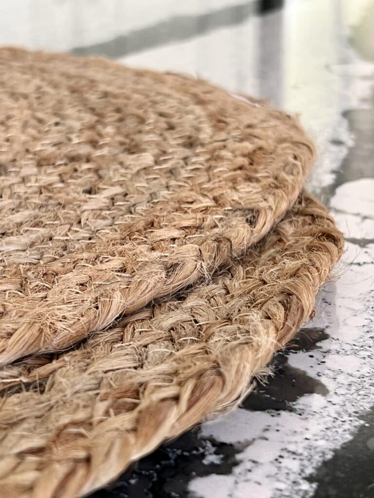 Two jute placemats sitting on a kitchen countertop.