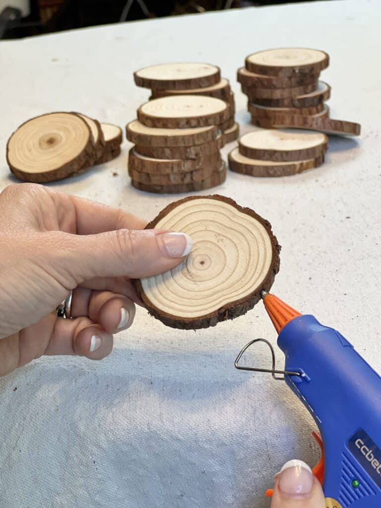 Glueing the side of a wood slice with a low temp glue gun.
