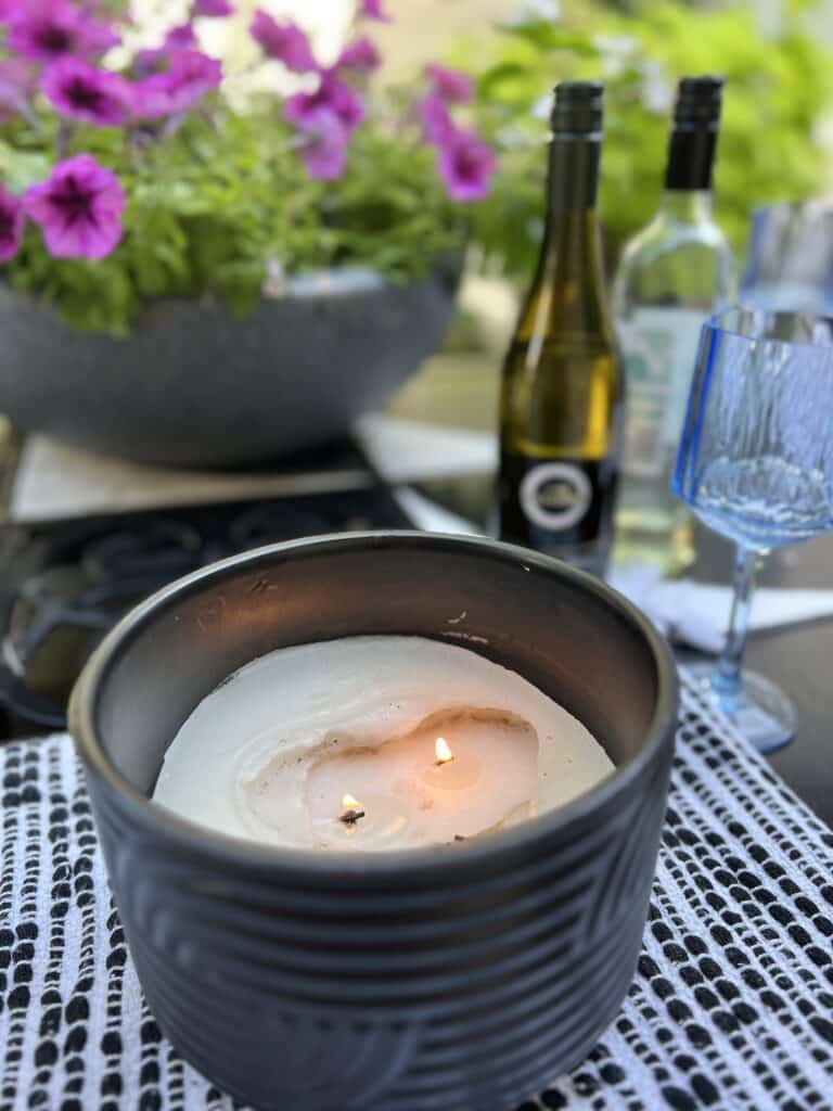 An outdoor citronella candle that has burned toward the bottom of the container.