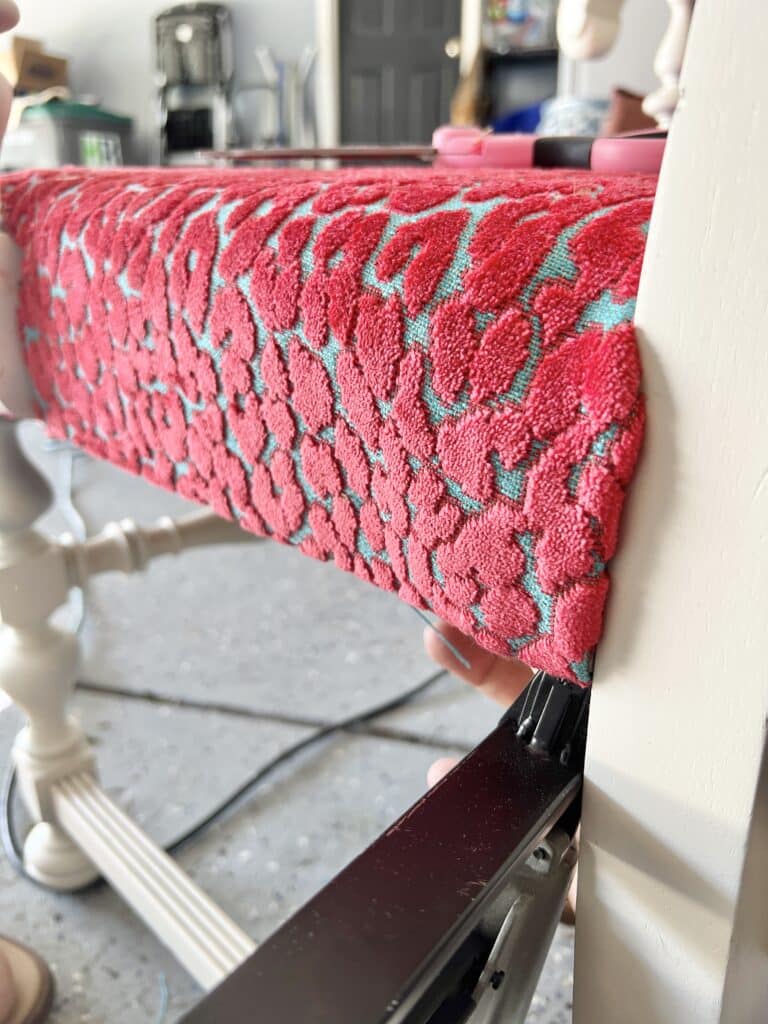 upholstery diy chair seat: stapling the back corner of a piece of fabric.