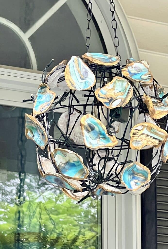 The DIY oyster shell chandelier hanging on the front porch.