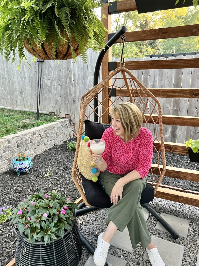 Missy sitting in an egg chair under the Toja Grid pergola.