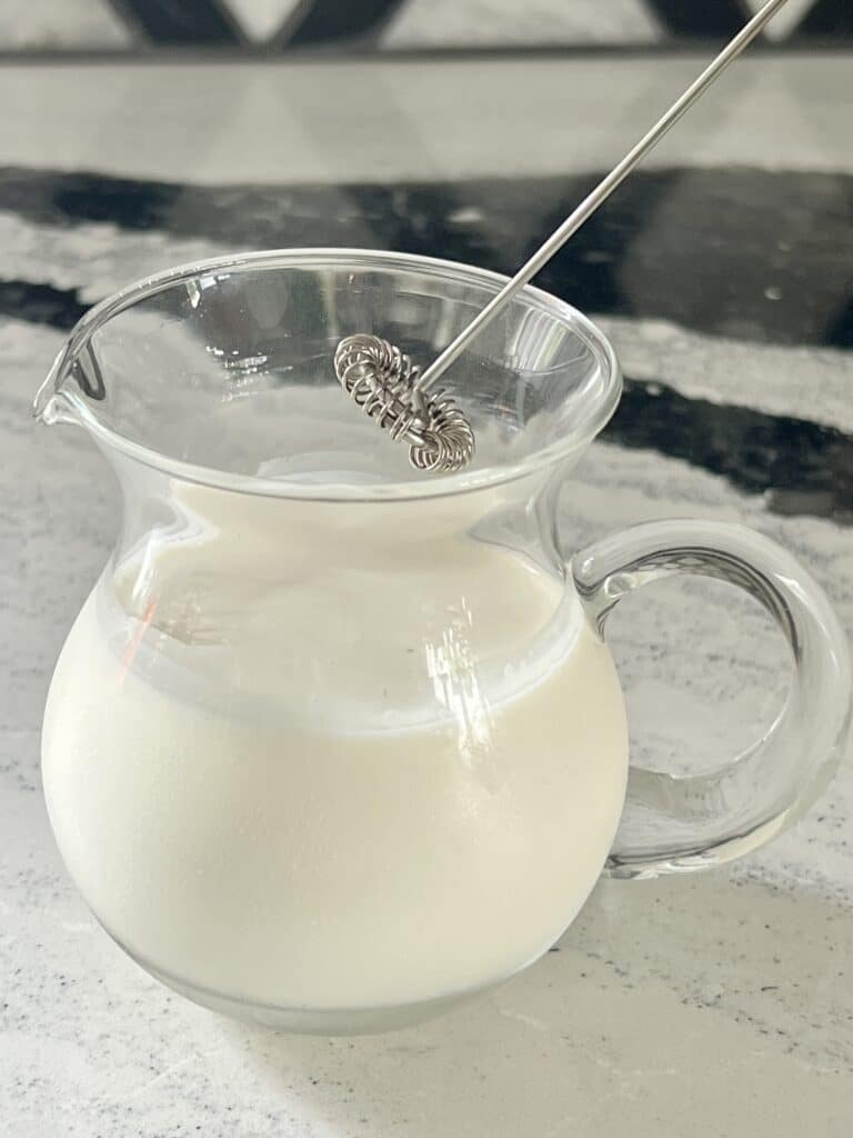 Butterscotch Latte Recipe: Frothing cream with a handheld frother.