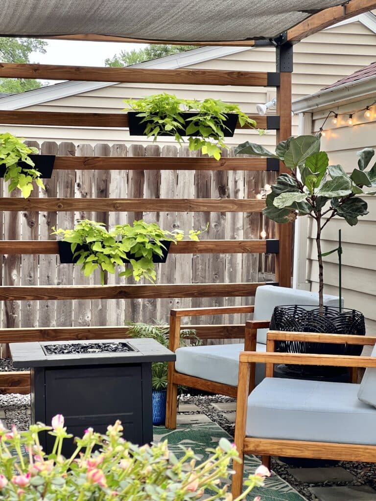 Two outdoor chairs sitting under the Toja Grid pergola.